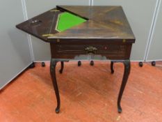 AN EDWARDIAN MAHOGANY ENVELOPE CARD TABLE having a green baize interior with gilt tooled edging