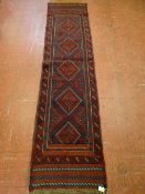 A MESHWANI CARPET RUNNER, blue and red ground with repeating central diamond pattern and double