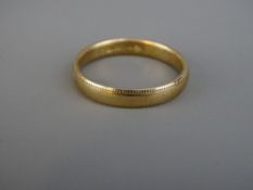 A NINE CARAT GOLD WEDDING BAND with fine ball edging, 3.5 grms, size 'V'
