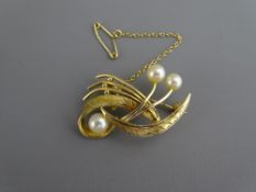 A NINE CARAT GOLD LEAF BROOCH with three pearls and safety chain, 4.9 grms