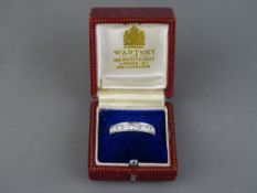 AN EIGHTEEN CARAT WHITE GOLD DIAMOND SET HALF ETERNITY RING, channel set with nine brilliant cut