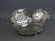 A CONTINENTAL SILVER TWIN HANDLED BREAD BASKET, pierced thatch cartouche and leaf and floral pattern