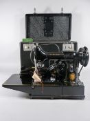 A SINGER 222K SEWING MACHINE with original foot pedal, rubber mat, accessories and booklets, in