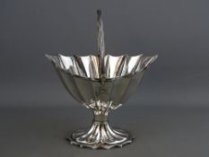A GEORGE III IRISH SILVER HELMET SHAPED SUGAR BASKET, reeded pattern swing handle and fluted body on