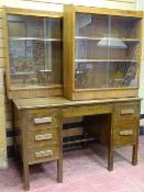 A VINTAGE OAK PEDESTAL DESK and a matching pair of walnut glass fronted bookcases, 78 cms high,
