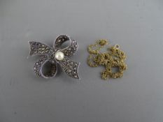 A FINE LINK NECK CHAIN (possibly gold), 1.2 grms and a marcasite bow brooch on a 925 silver back and