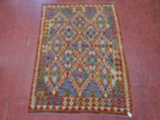 A VEGETABLE DYE WOOL CHOBI KELIM MULTI-COLOURED RUG with repeating central diamond block pattern and