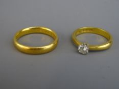 TWO TWENTY TWO CARAT GOLD RINGS including a wedding band, size 'Q', 5.9 grms and a solitaire ring,