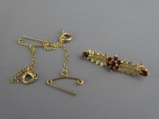 A NINE CARAT GOLD FERN BAR BROOCH with ruby centre cluster and ends, 1 grm and two nine carat gold