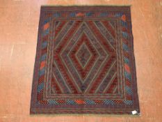 A CAZAK RUG, red and blue ground with diamond centre and chevron block pattern, with multi-