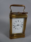 A DROCOURT FRENCH BRASS CASED CARRIAGE CLOCK with visible escapement, the white dial set with