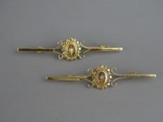 A PAIR OF NINE CARAT GOLD BAR BROOCHES with oval pearl set centres, 4.2 grms
