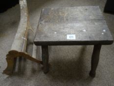 A vintage four legged stool and a saddlerack.