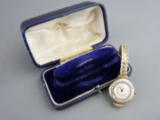 An eighteen carat gold cased lady's wristwatch with diamond set bezel on a plated bracelet strap,