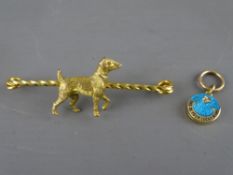 A nine carat gold terrier dog bar brooch, 5.9 grms and a fifteen carat gold and enamel lucky star
