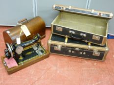 A vintage cased Singer sewing machine and two banded travel cases
