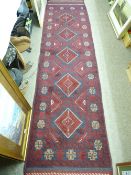A MESHWANI CARPET RUNNER, red ground with block cross pattern border and central repeating diamond