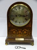 A dome topped inlaid mahogany mantel clock with twin fusee gong strike movement behind a silvered