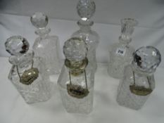 Six cut and other glass decanters with stoppers, some with labels