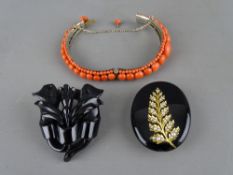 A Victorian coral bangle, a jet type floral brooch and a possibly oval Victorian jet and yellow