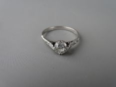 An eighteen carat white gold diamond solitaire ring, 0.75 carat with four tiny diamonds set to