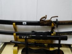 Four reproduction Japanese swords on display stands