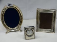 A silver portrait frame and one other and a silver fronted desk clock, 6.5 cms high (modern