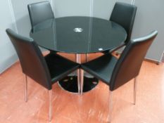 An ultra modern chrome and black glass topped circular dining table and four chairs, 110 cms
