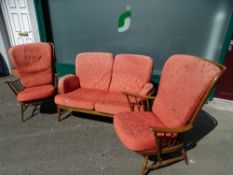 Mid Century Ercol stick back three piece lounge suite of two seater couch and a pair of armchairs,