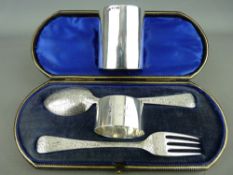 Cased silver christening set and a small bottle holder, the set comprising fork and spoon, chased