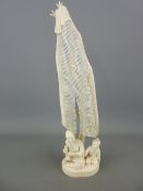 19th Century carved ivory Okimono depicting a man and a young boy seated beneath a drying fishing