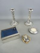 Silver box with bevelled edge glass lid, a pair of silver candlesticks, a small circular photo frame