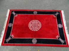 Good red and black pattern Chinese washed woollen carpet with tasselled ends, 178 cms wide