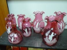 Collection of cranberry glass Mary Gregory style vases and jugs (eight), to include three 21 cms