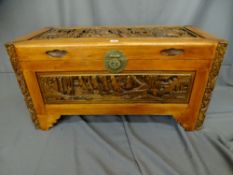 Neat Oriental camphorwood chest having carved corner pillars and the lid and front carved with ships