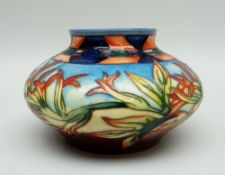 A MOORCROFT POTTERY SQUAT VASE in the 'Indian Paintbrush' pattern dated 2000, 12cms high (boxed)
