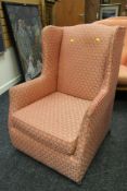 A GOOD VINTAGE WING-BACK ARMCHAIR having fan patterned pink upholstery