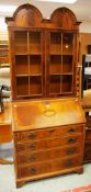 A TWIN-DOME TOP BUREAU BOOKCASE having sectional glazed upper section, sloped front and four