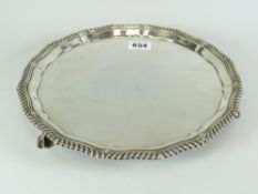 SILVER PIECRUST EDGE SALVER raised on three ball and claw feet, Sheffield hallmarked 18 troy ounces,