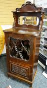 A CARVED MIRROR BACK EDWARDIAN MAHOGANY MUSIC CABINET with four front base and upper glazed door,