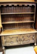 A VINTAGE CARVED DRESSER WITH OPEN RACK and two-cupboard base
