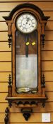 A MIXED WOOD VINTAGE VIENNA TYPE WALL CLOCK having circular white enamel dial bearing roman