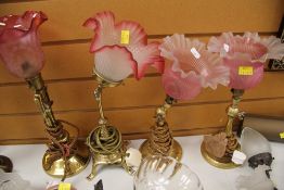 A PAIR OF ADJUSTABLE BRASS AND TINTED GLASS READING LIGHTS and two further adjustable reading lights