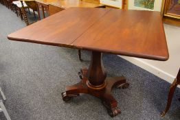 AN ANTIQUE MAHOGANY FOLDOVER TEA-TABLE on shaped scrolling supports and baluster faceted column,