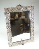 A LARGE TABLE MIRROR with mounted silver decoration in the Art Nouveau floral style, having bevelled