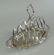 GEORGE V SILVER SIX SECTION TOAST RACK OF OVAL FORM raised on four ball feet with loop handle.