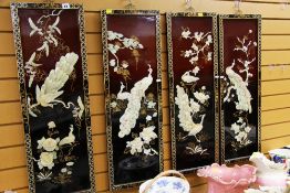 FOUR C20TH ORIENTAL PANELS in lacquer with applied peacocks and foliage and having decorative