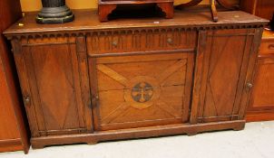 AN ARTS AND CRAFTS STYLE SIDEBOARD with centre heraldic panel, side cupboards and drawer