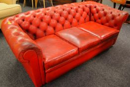 A THREE SEATER CHESTERFIELD TYPE SETTEE in red leather