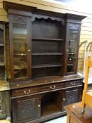 AN EDWARDIAN CARVED DRESSER with semi-glazed rack and kennel recess